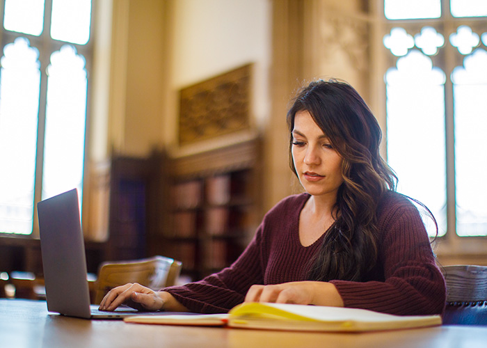 student studying with laptop in the Great Reading Room in Bizzell library