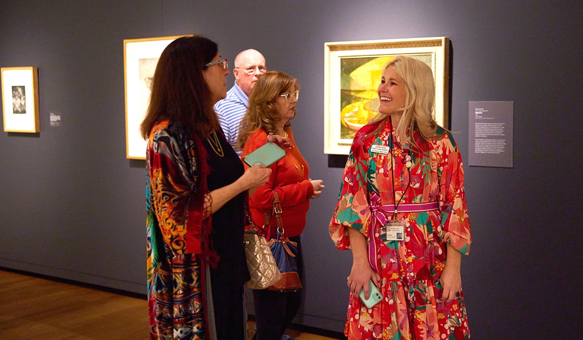 Three women admiring paintings in an art museum.