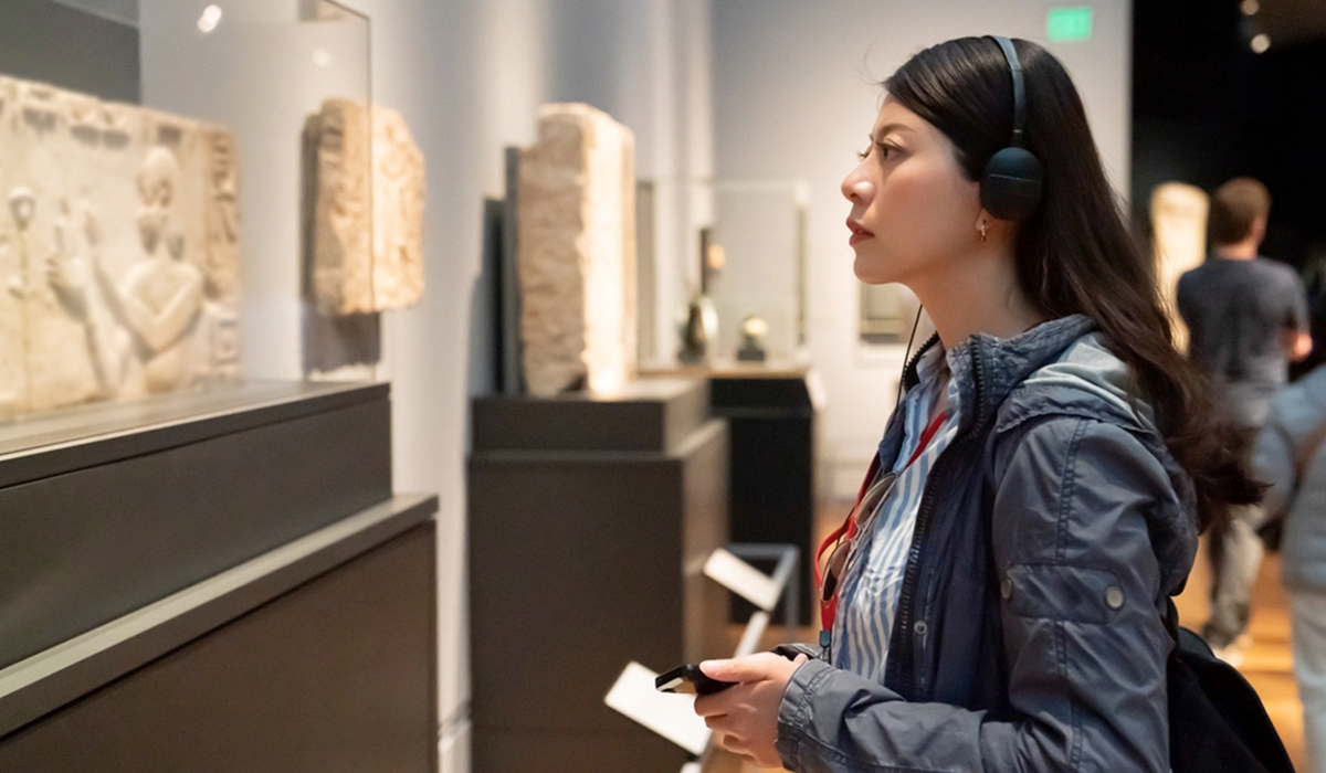 woman taking notes about a collections display in a museum