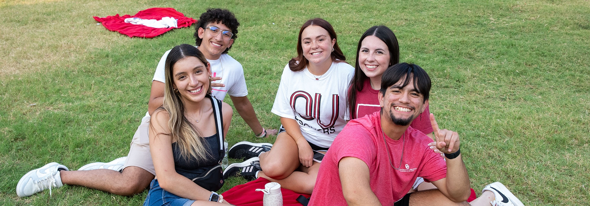 Students sitting in the grass at the University of Oklahoma.