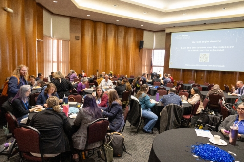 A large group of people sitting at tables during the Academic Tech Expo.