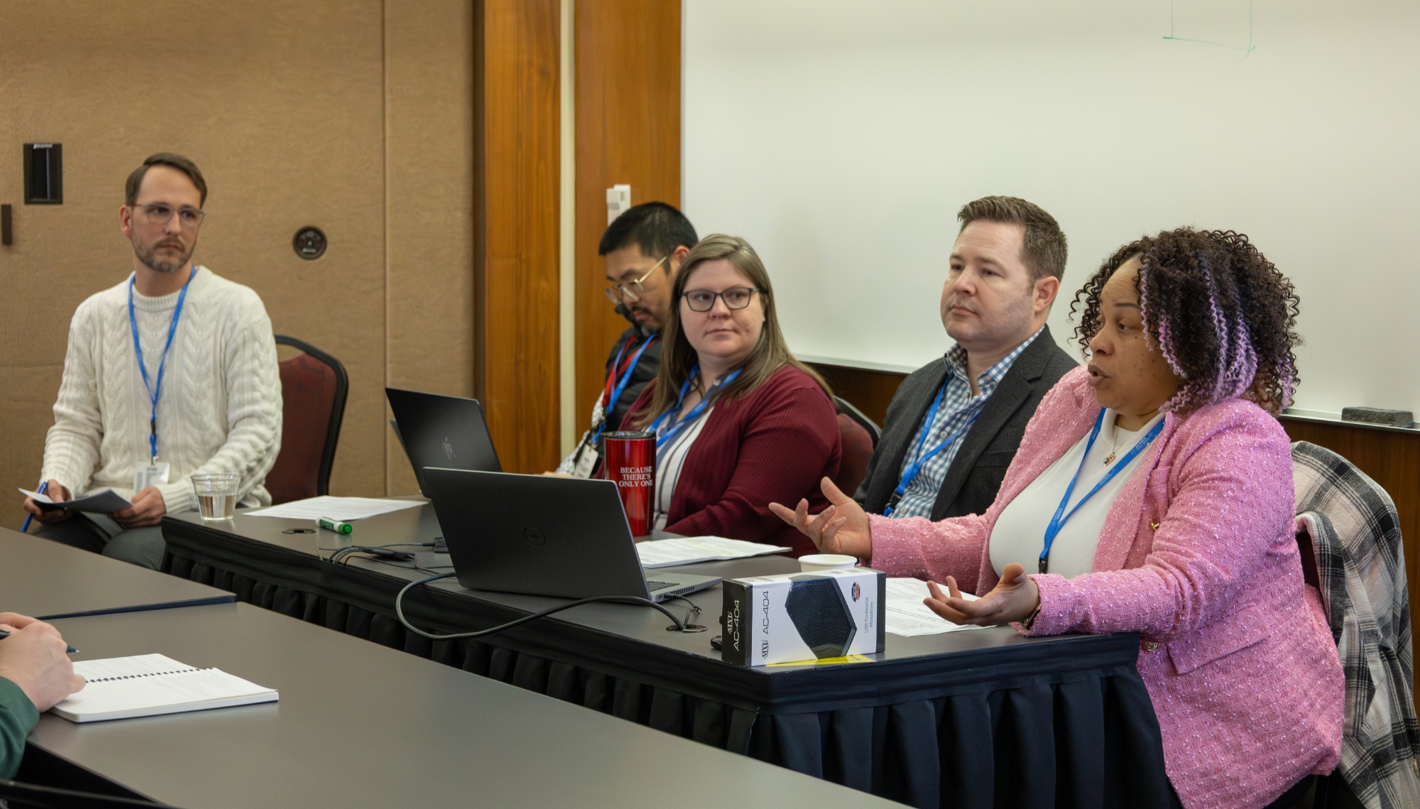 Five people talking as a panel at a table.