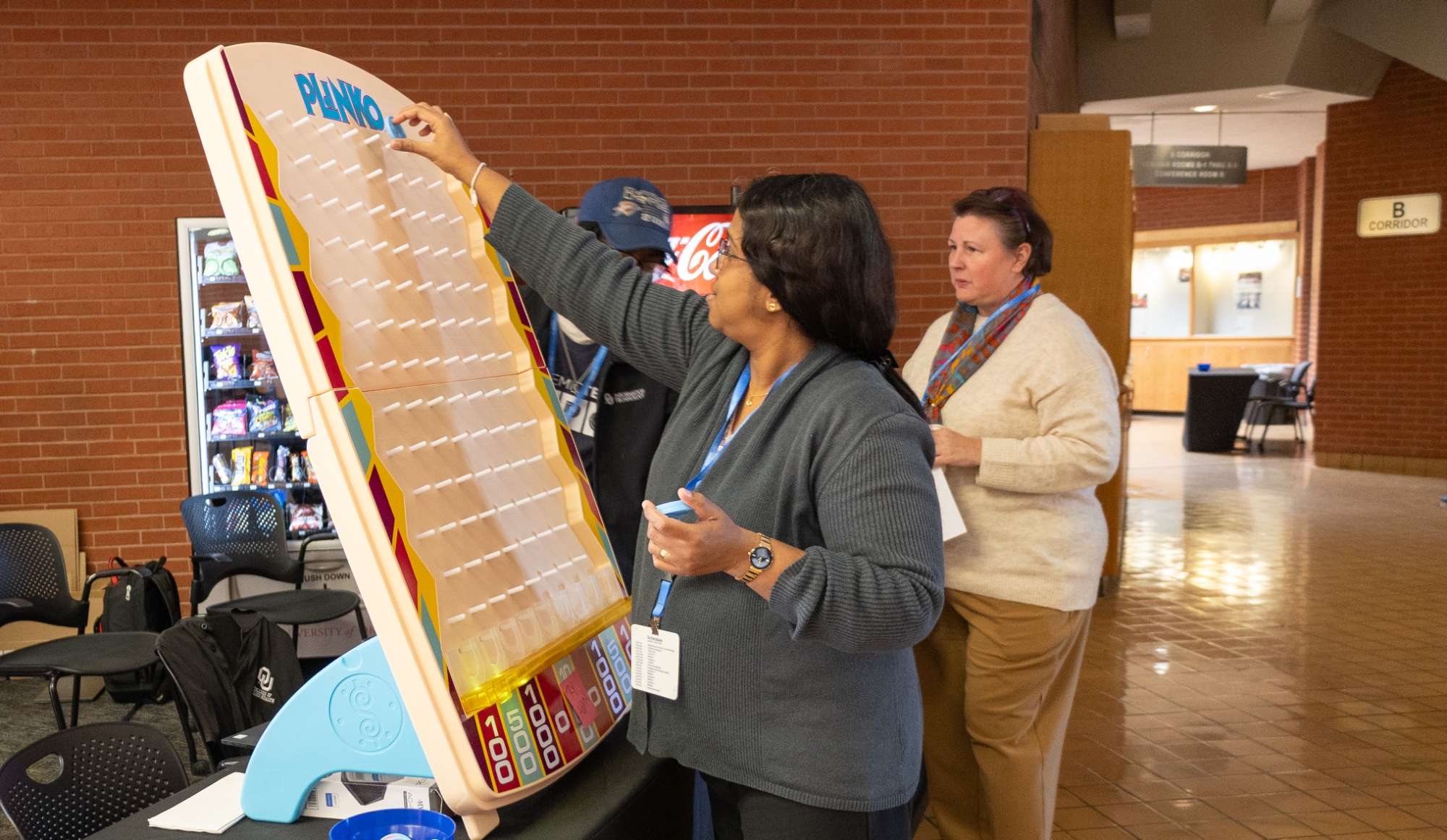 A person dropping a disc into a plinko game.