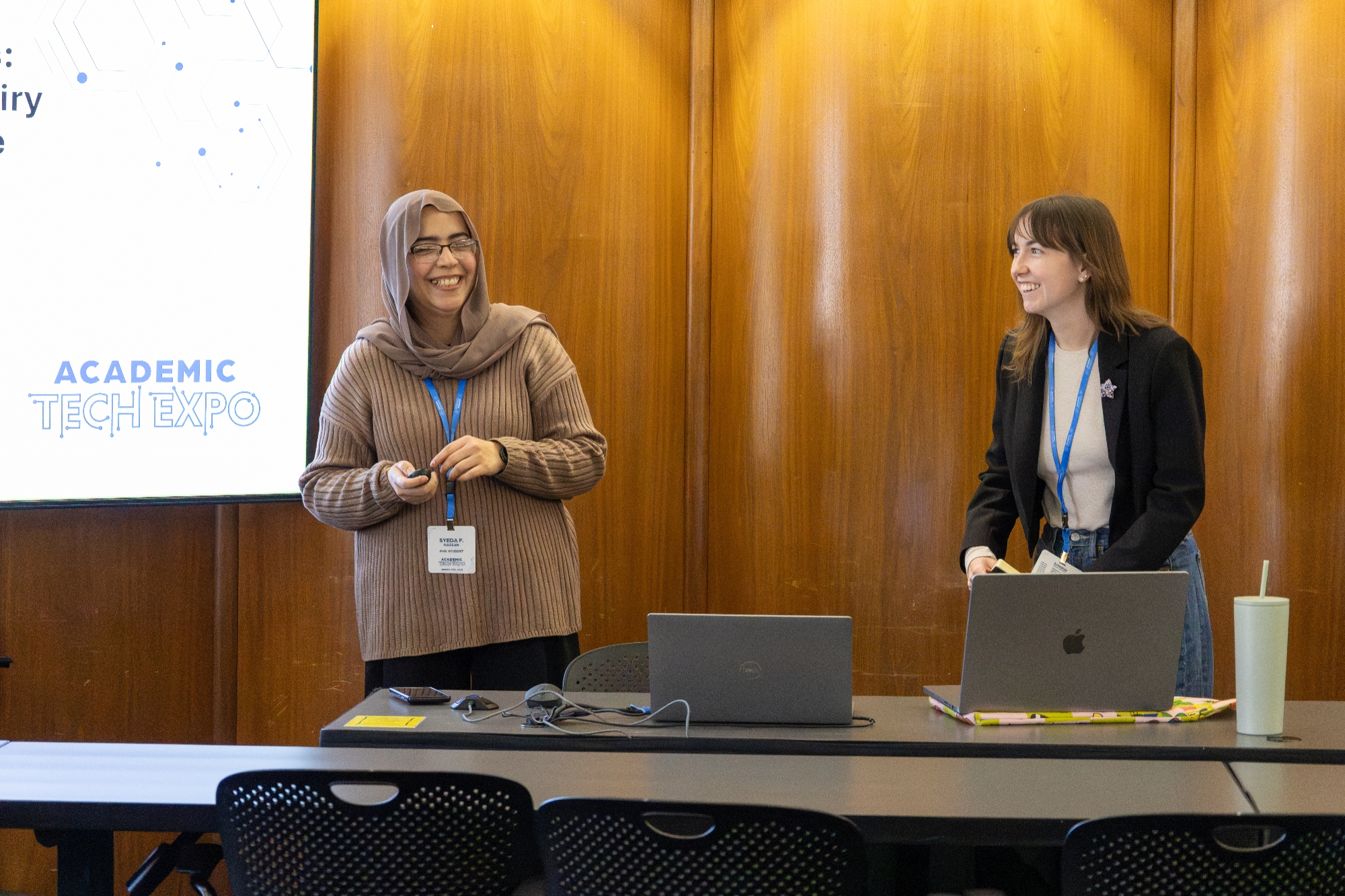 Two people smiling while presenting at the Expo. 