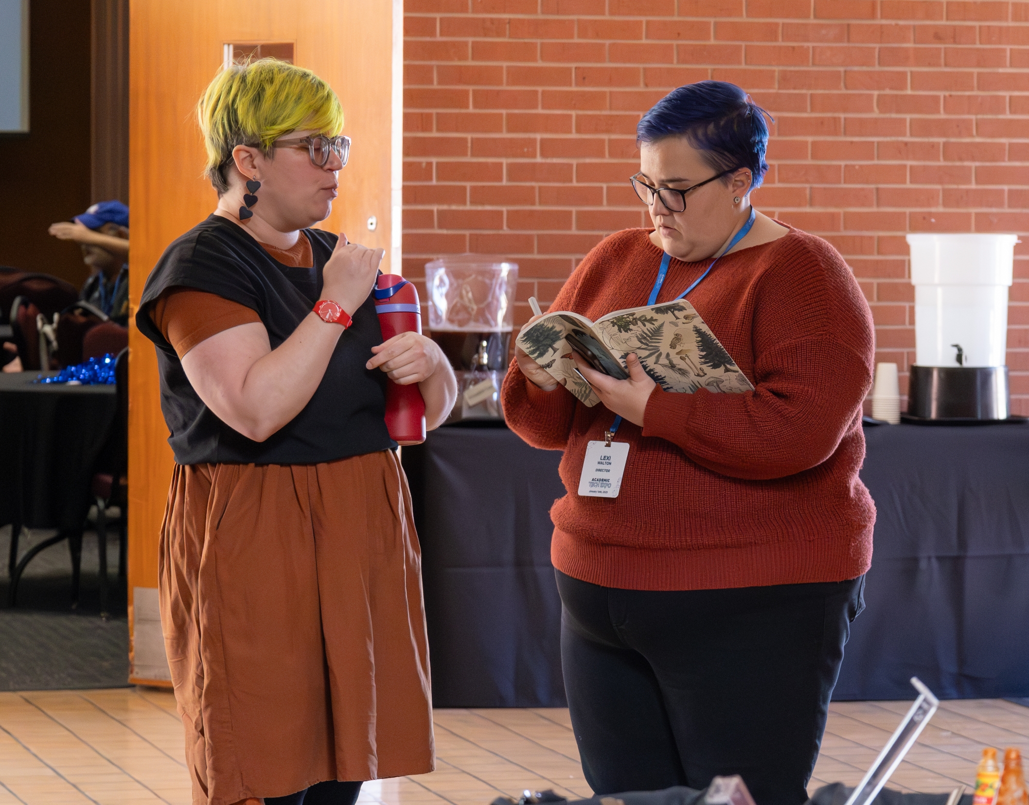 Two people talking. One person is taking notes.