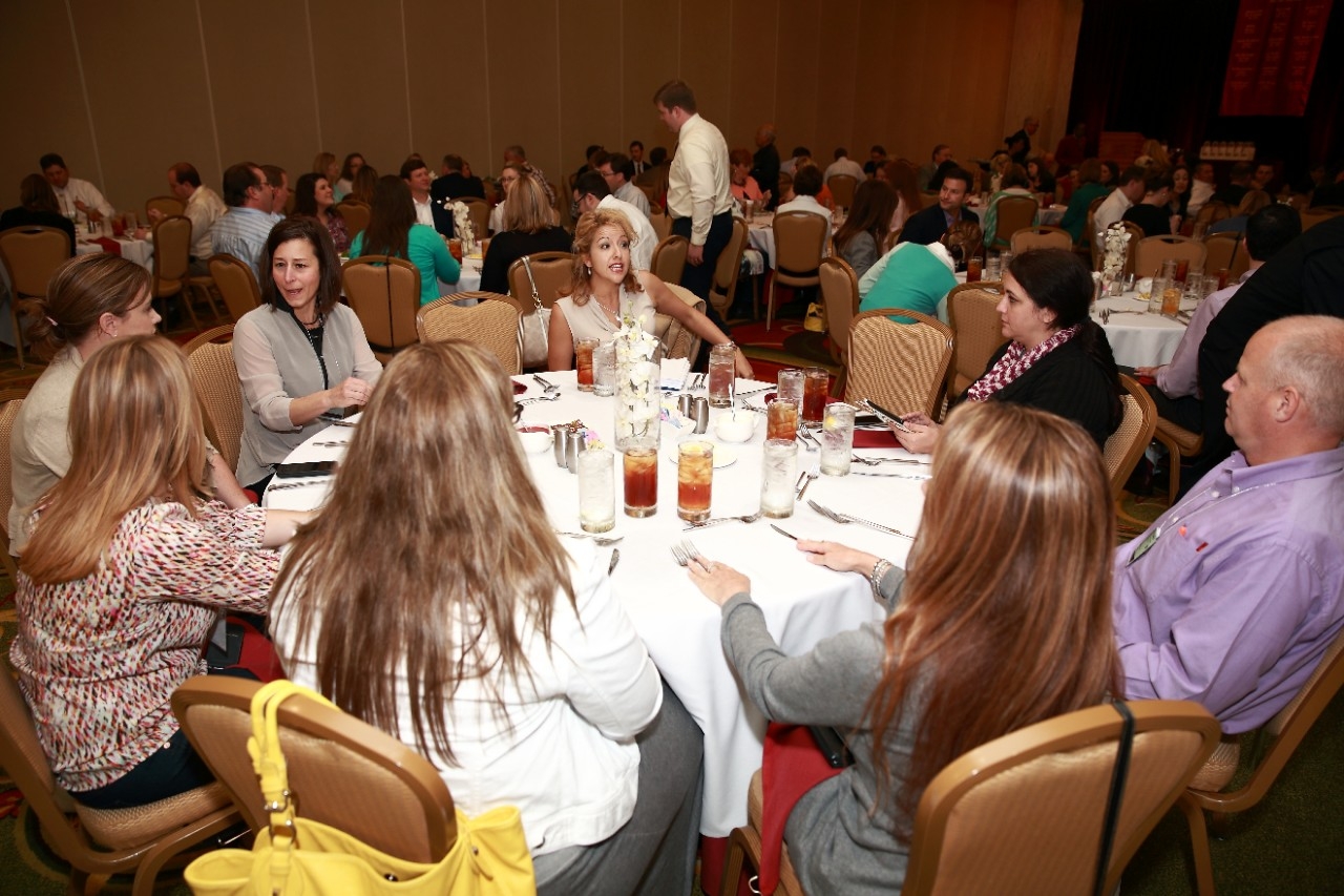 Business associates at a dinner table networking with each other.