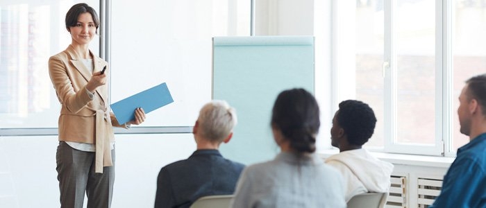 young professional woman giving a presentation to four co-workers