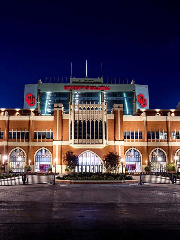 Gaylord Family Oklahoma Memorial Stadium lit up at night.