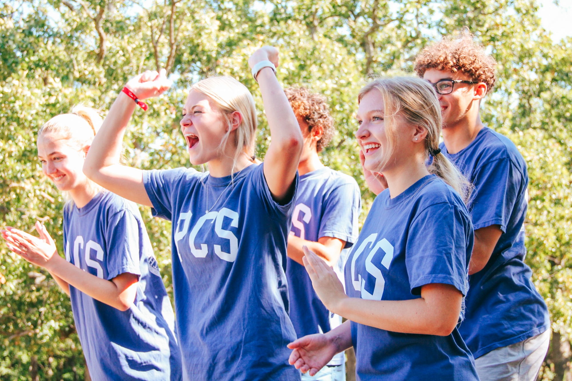 Students cheer on their peers at the low-ropes course.
