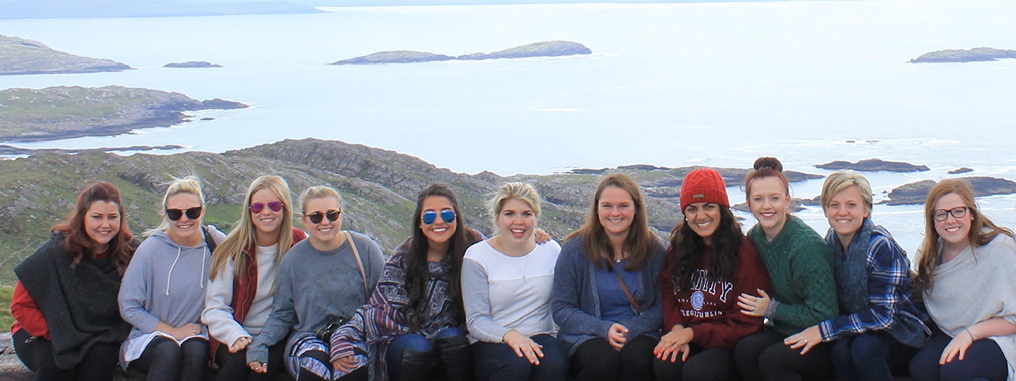 PLC students in a group photo with the Ireland coast behind them.