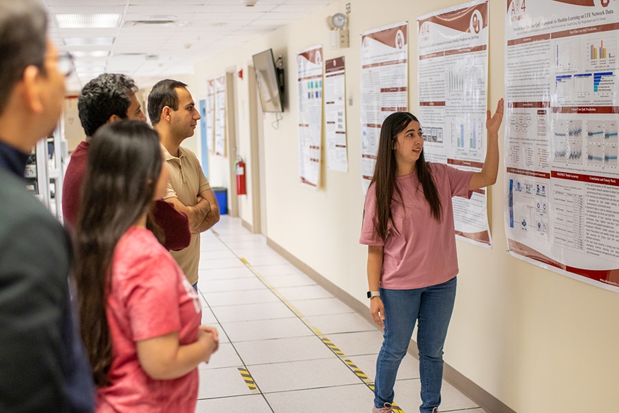 student presenting poster to audience. 