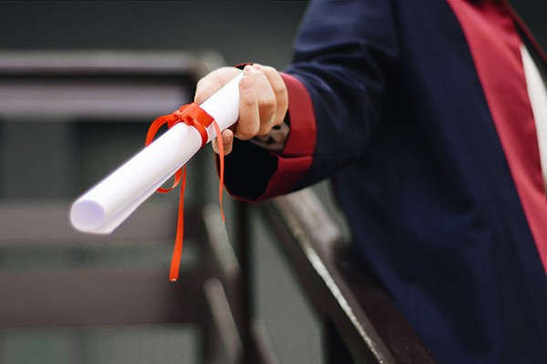 close-up photograph of a hand holding a diploma