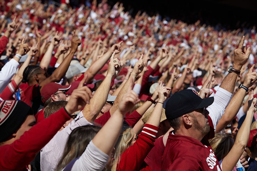 A large group of OU Fans giving the One OU hand gesture.