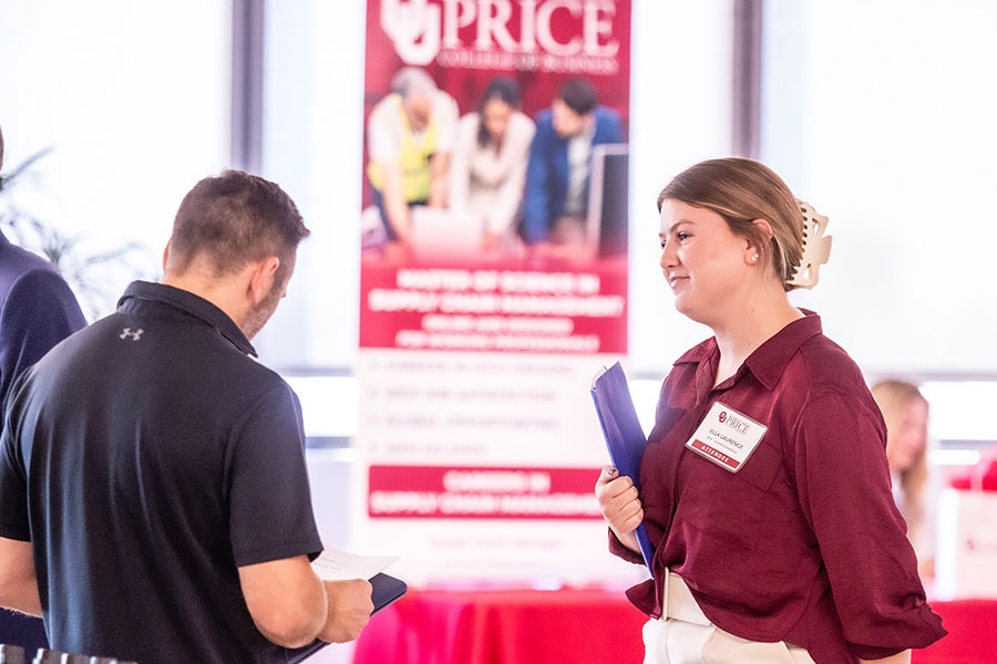 An OU representative talks to prospective employers at a corporate networking event. 