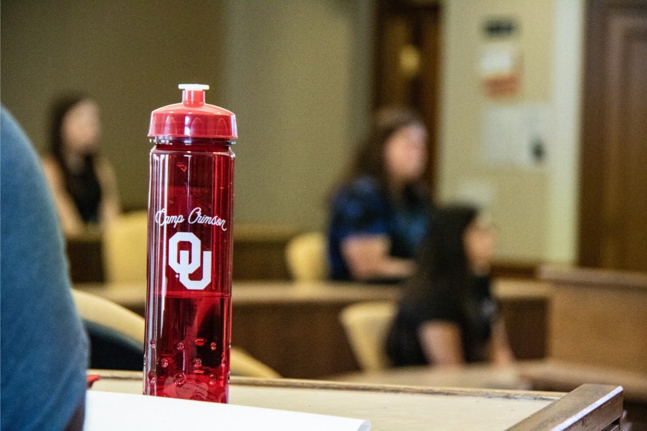 An OU water bottle sits on a desk.