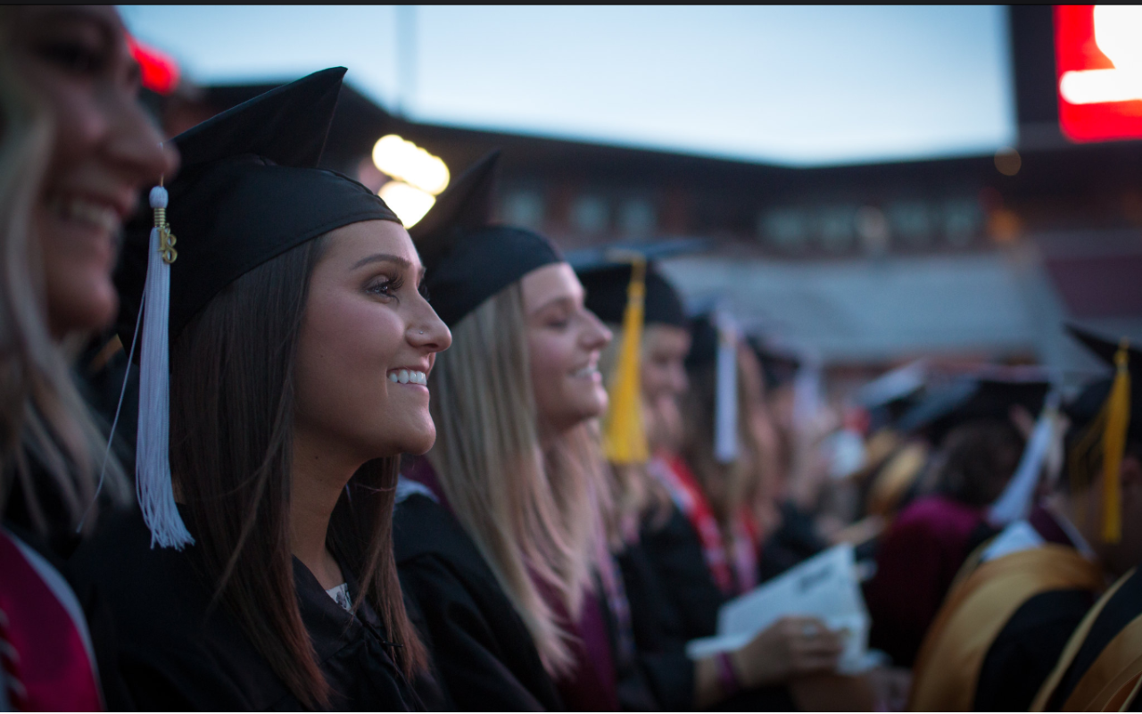 Graduates smile and listen as speeches are given during OU's 2018 Commencement, at the Gaylord Family Oklahoma Memorial Stadium.