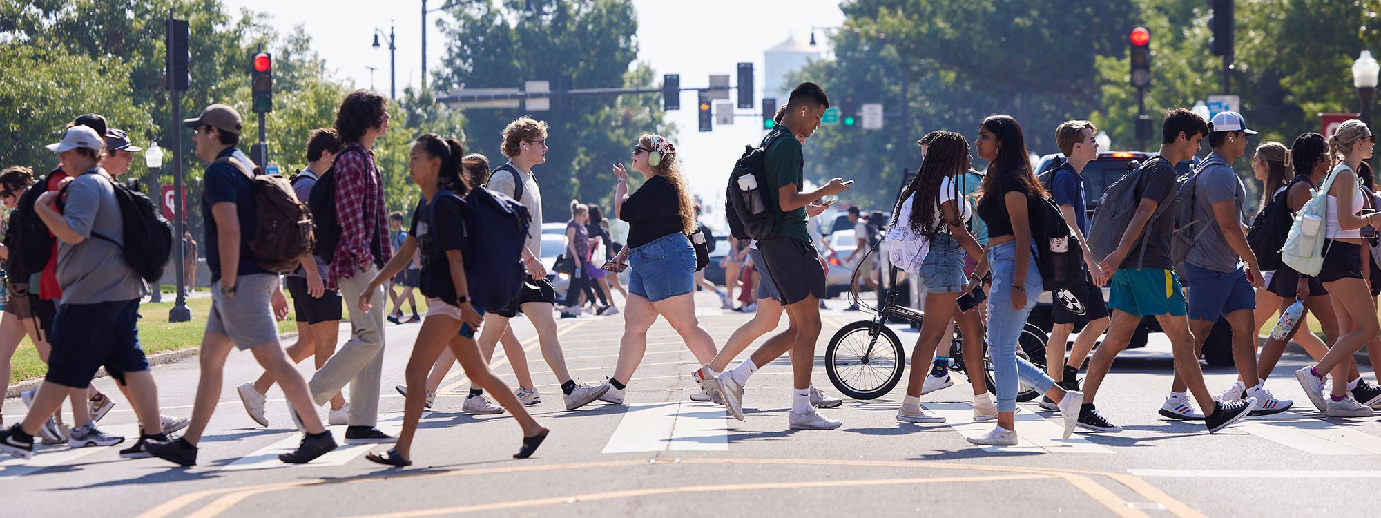 A busy crosswalk with students crossing.