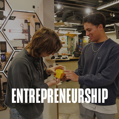 Two students working together on a prototype in the innovation lab. Text over photo reads: Entrepreneurship