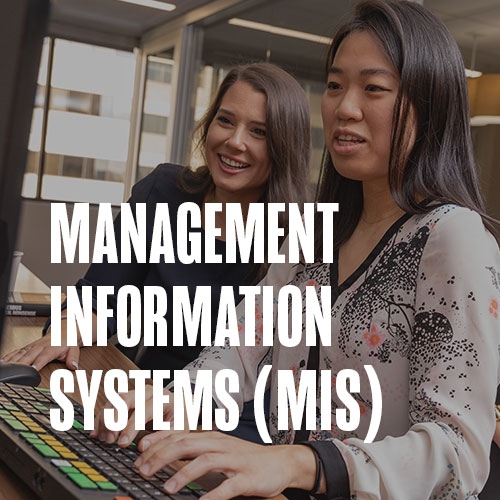Two women siting together while working cooperatively on a computer. Text over photo reads: Management Information Systems (MIS)