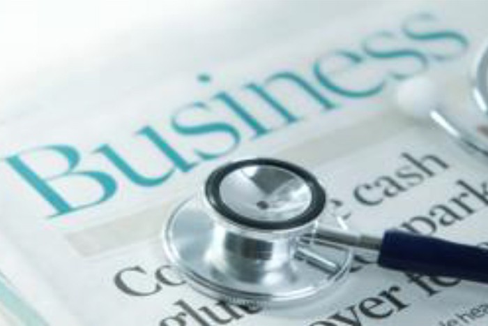 Business newspaper and stethoscope