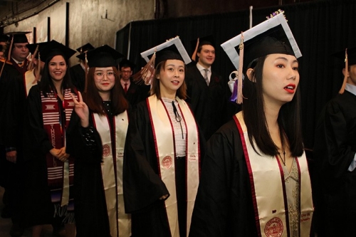 Student in cap and gown prepare to walk for convocation
