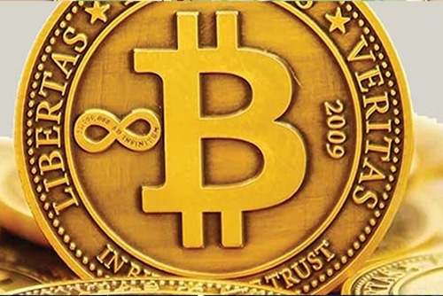 Closeup of a gold coin embossed with a large B representing bitcoin crypto currency
