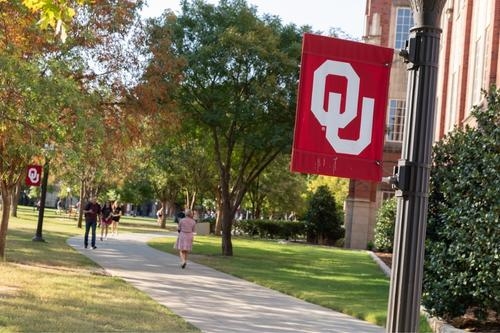 A crimson OU flag adorns the sidewalk on the east side of Adams Hall on the Norman, OK. campus. 