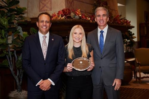 Olivia Griffin displays her award for a photo with OU President Joseph Harroz, Jr. (left) and Wayne Thomas (right), Sr. Assoc. Dean of Faculty Research and Innovation at Price College