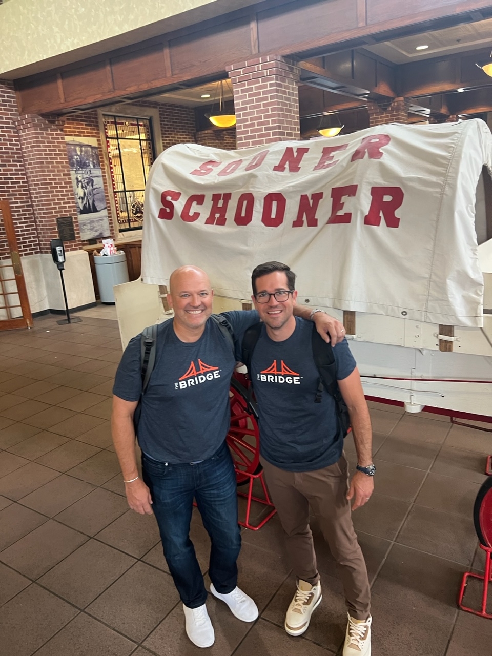 Eric Winton and Robby Riggs stand in front of the Sooner Schooner inside OU's student union.