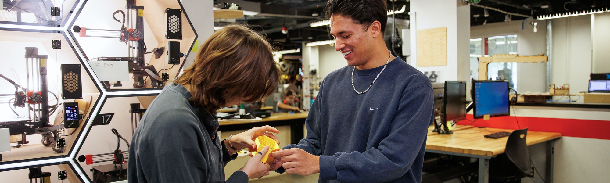 Two students work together on a 3D porotype in the fabrication lab.