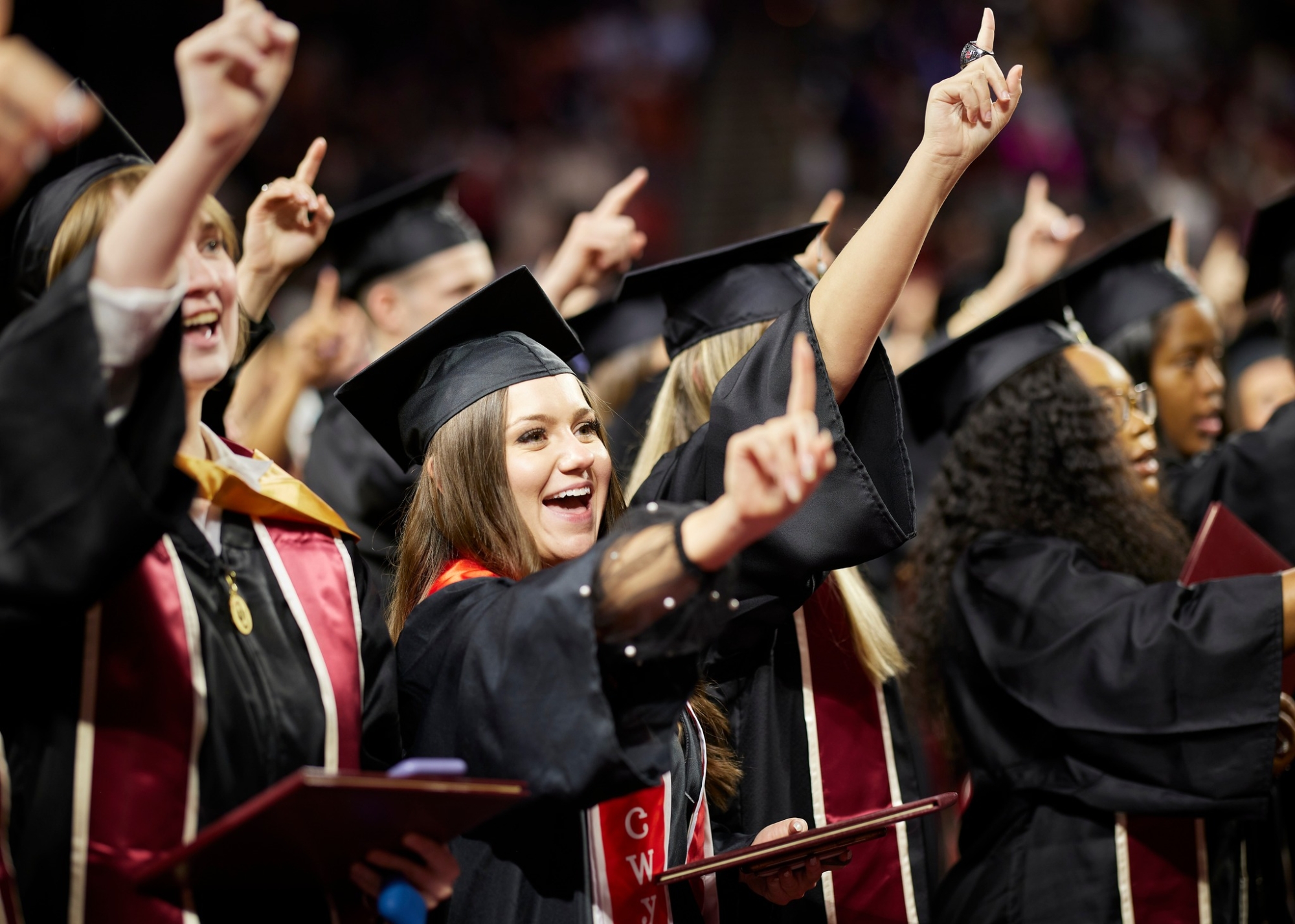 Group of graduates hold up pointer finger to OU Chant