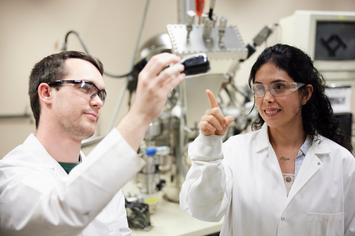 Graduate students Caleb Bavlnka and Alejandra Gomez discuss sample of carbon nanotubes.