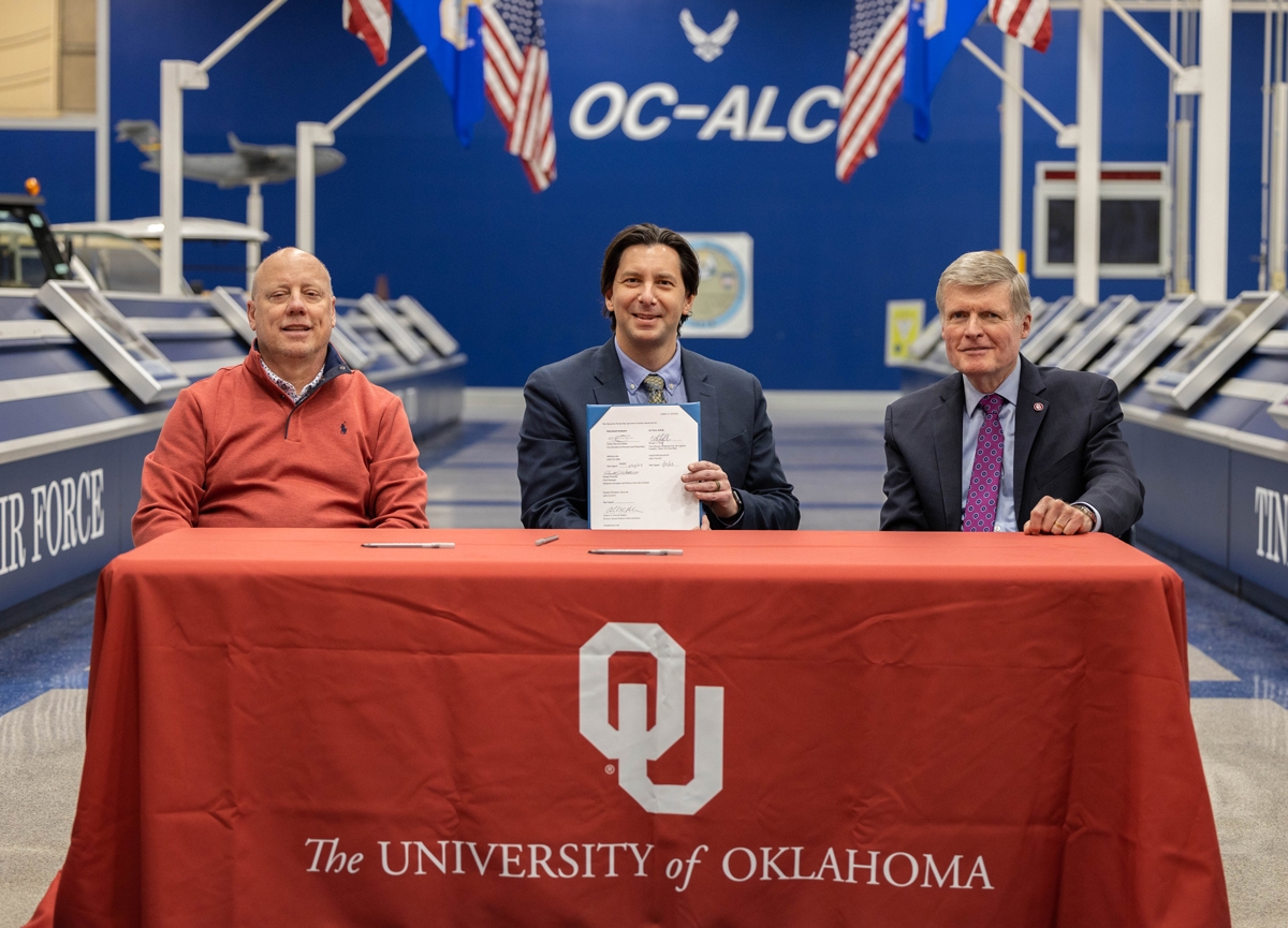 Sam Roberts Noble Microscopy Laboratory Director Andrew Elwood Madden holds signed agreement formalizing the donation of a metallograph microscope to the University of Oklahoma. Elwood Madden is joined by donor signatory Wayde Loflin, Oklahoma City Air Logistics Complex Vice Director (left) and OADII Chief Strategist Don Wetekam (right).