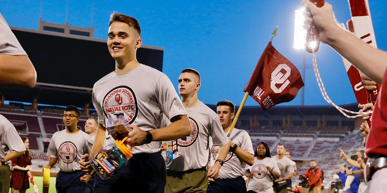 Naval ROTC students running in the OU stadium.