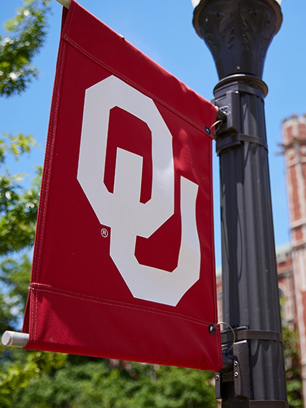 An OU flag hanging on a lamppost on the University of Oklahoma Norman campus.