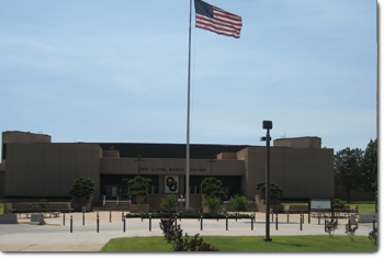 exterior view of lloyd noble center building with large USA flagpole in front