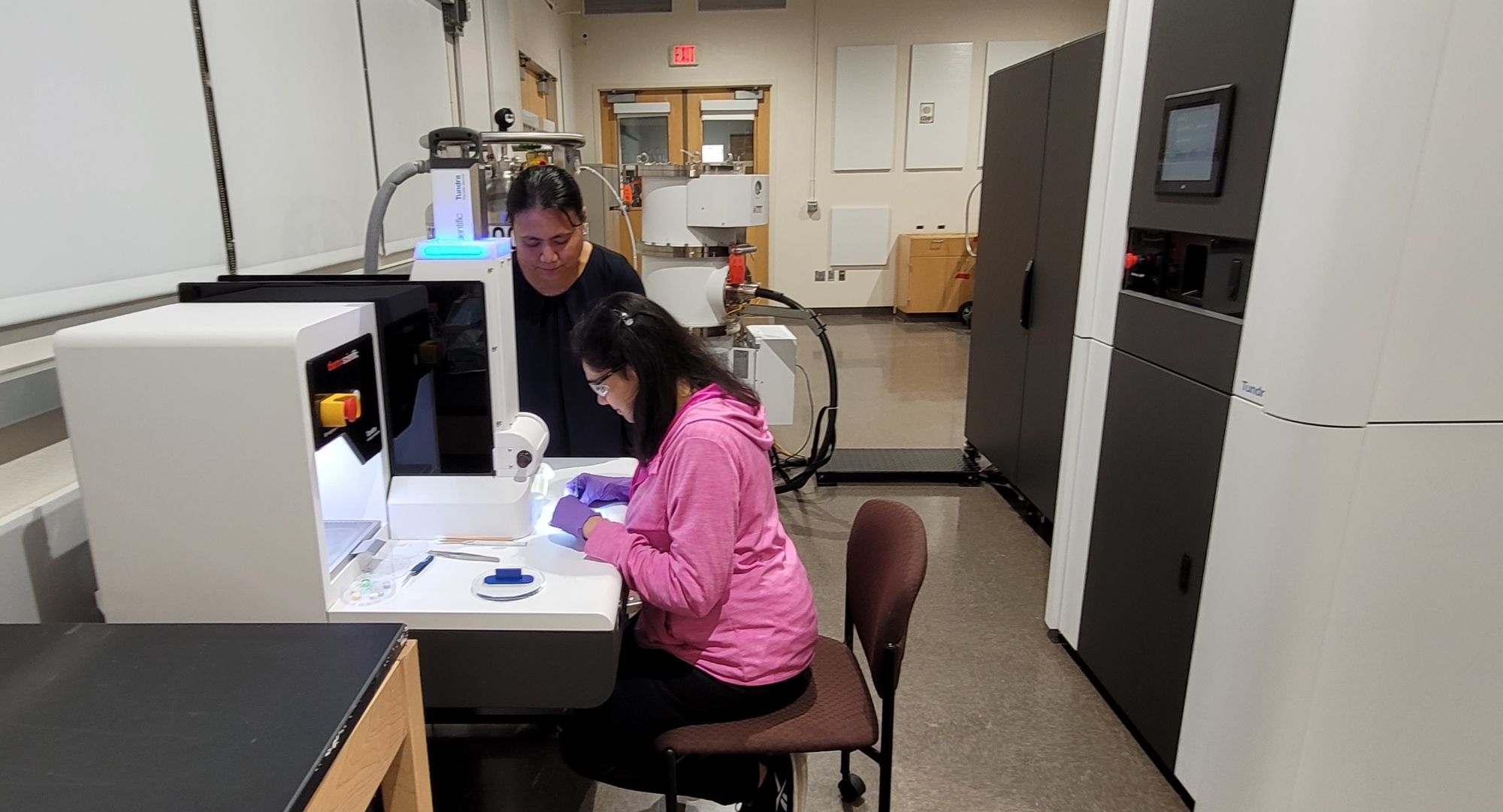 Picture of a person working at the loading station of the OU cryoEM Tundra and the Tundra
