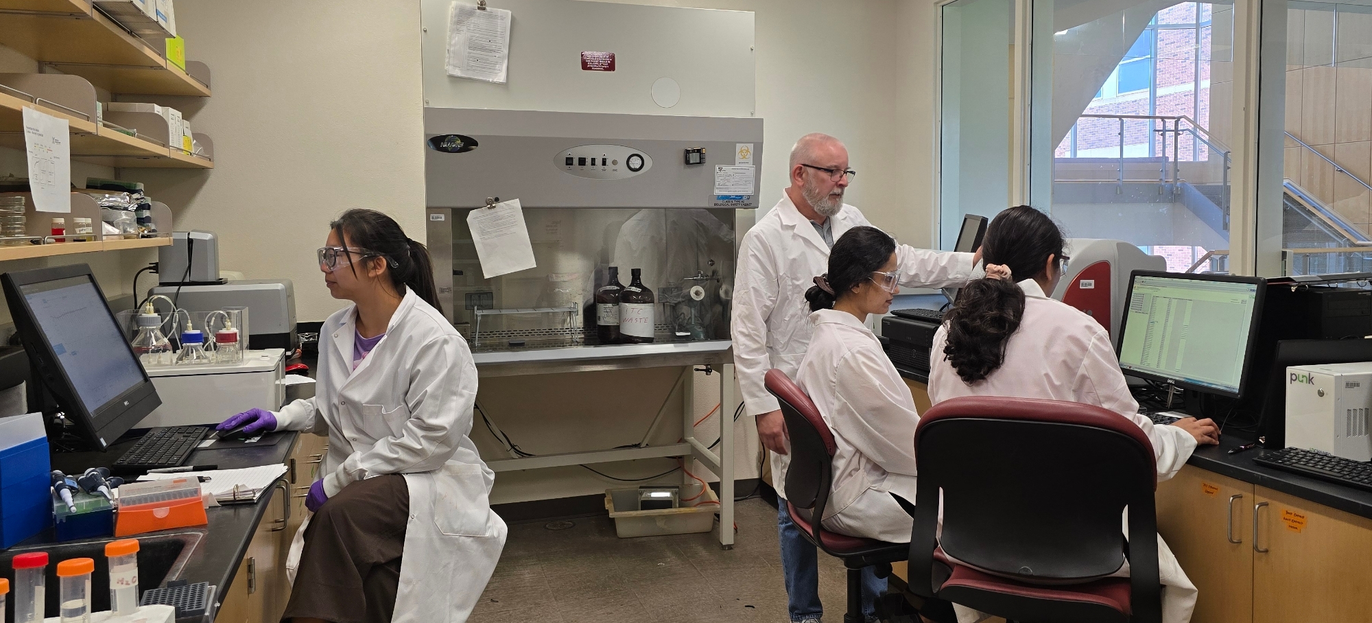 photo of instrument room of PPCC with 3 persons at the equipment