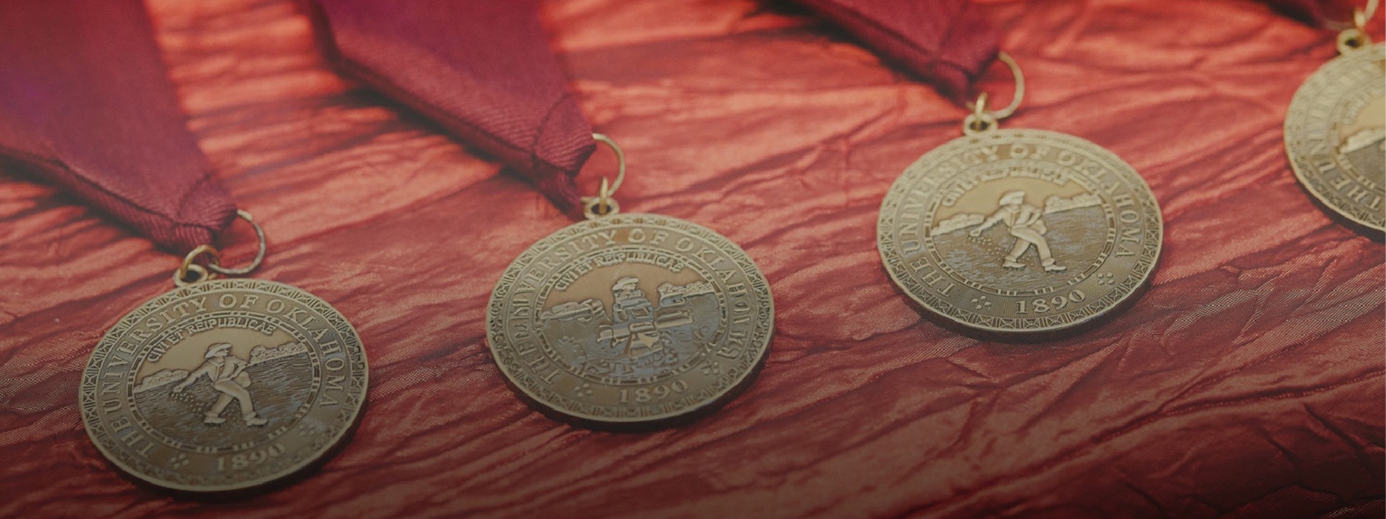 OU medallions laid out on table with red tablecloth.