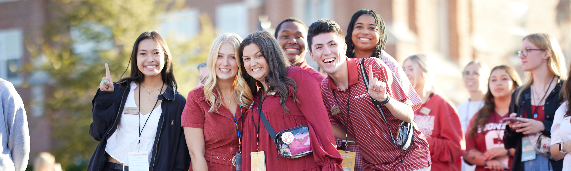 OU Students smiling and holding one finger up during the Homecoming parade.