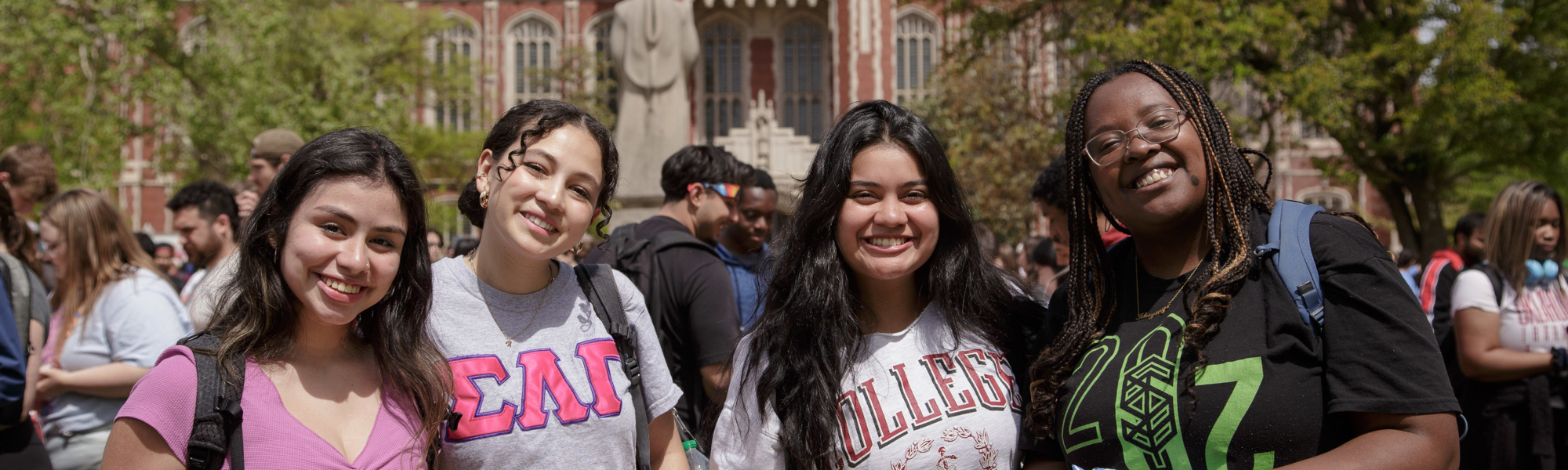 A group photo of students smiling in front of the Bizzell Memorial Library