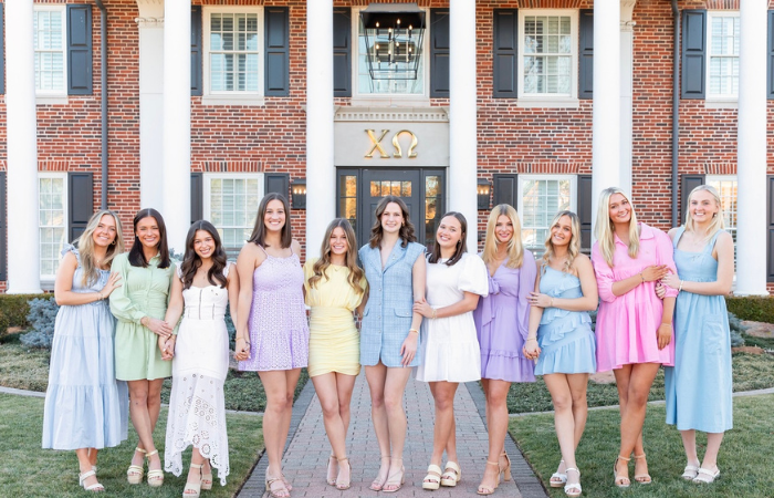 Chi Omega members pose for a group photo in front of the chapter house.