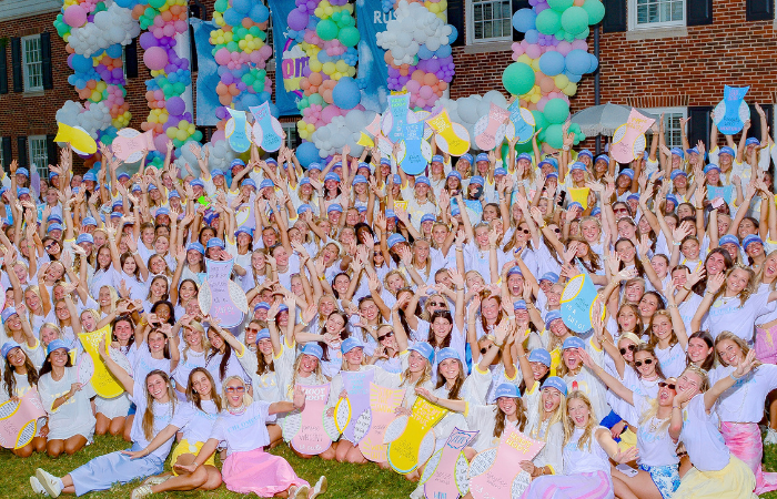 Chi Omega members pose for a group photo in front of the chapter house.