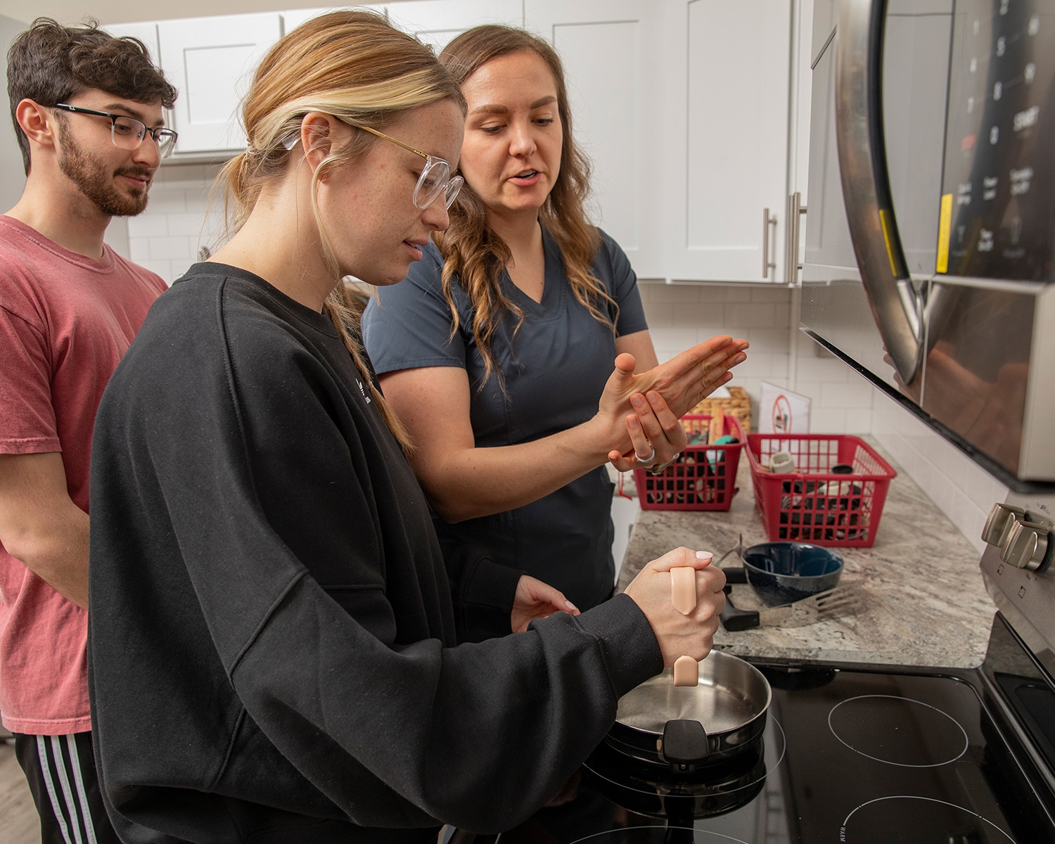 An OT instructor explains the correct useage and benefit of an adaptive kitchen implement.