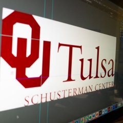 The OU-Tulsa logo show in profile on a screen as it is edited in a design program