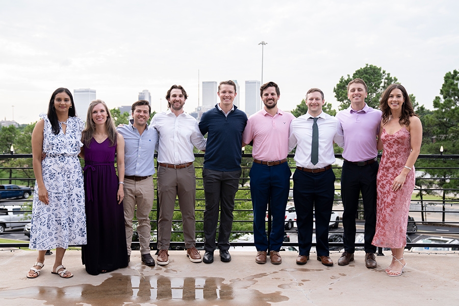 The class of 2027 students in business casual clothing, standing together outside.