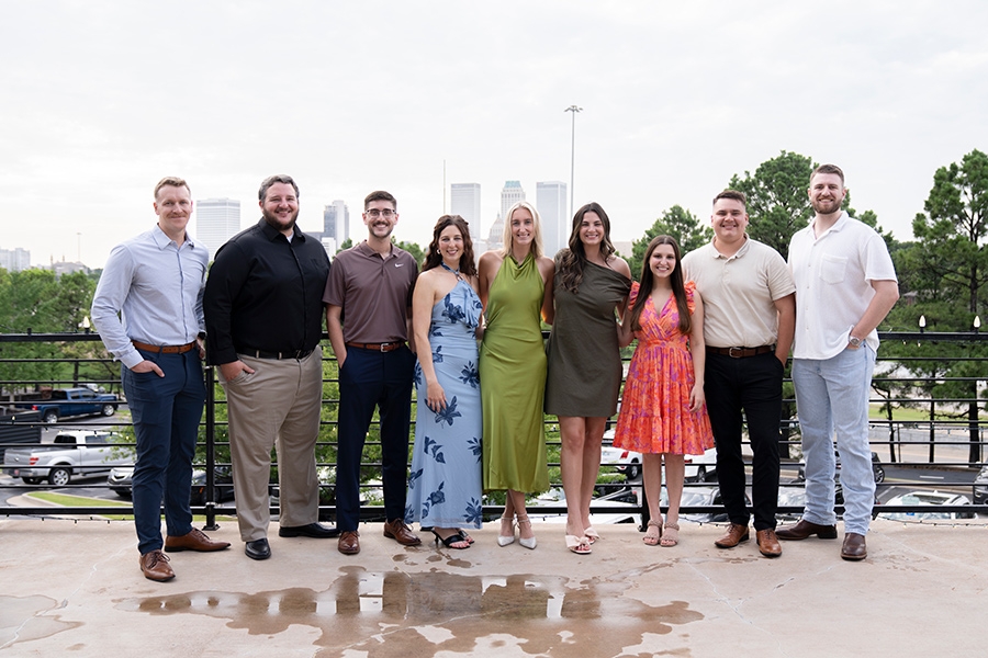 The class of 2028 students in business casual clothing, standing together outside.