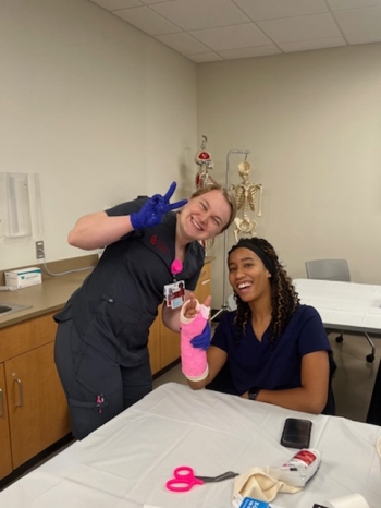 Two students practicing how to set a cast.