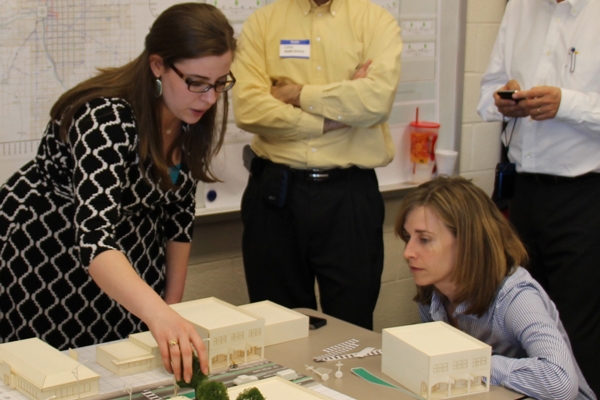 Urban design students inspect and analyze a scale model of a building