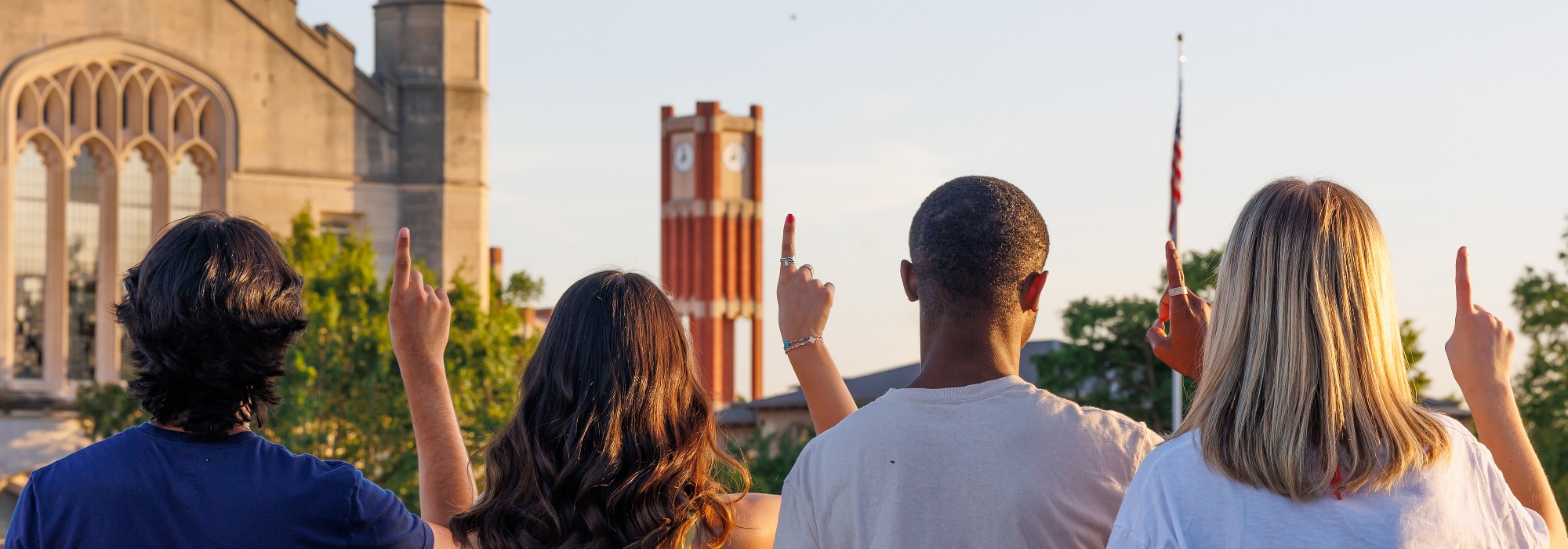 Four students facing clock tower